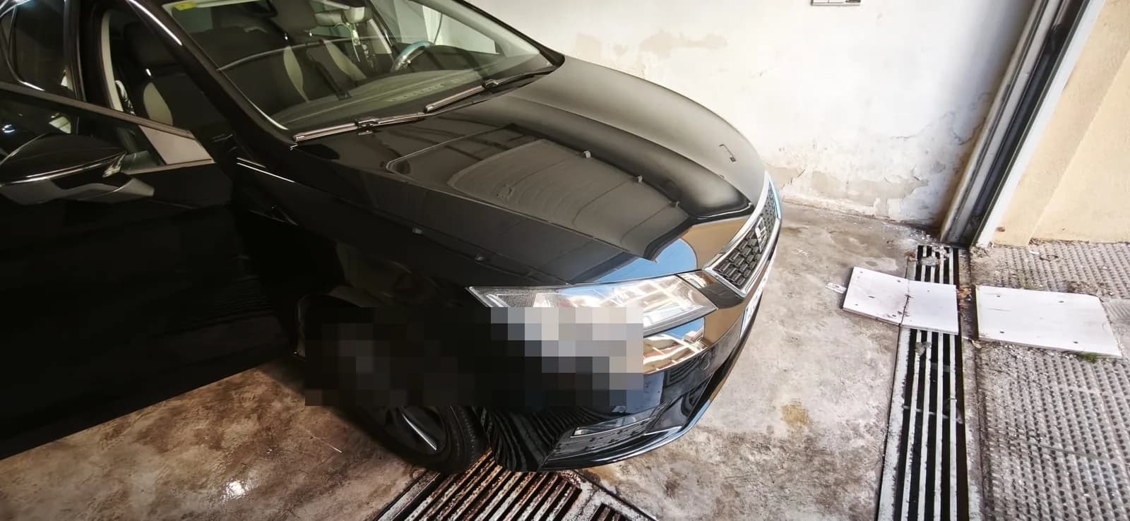 Coche negro con el frontal detallado en el taller