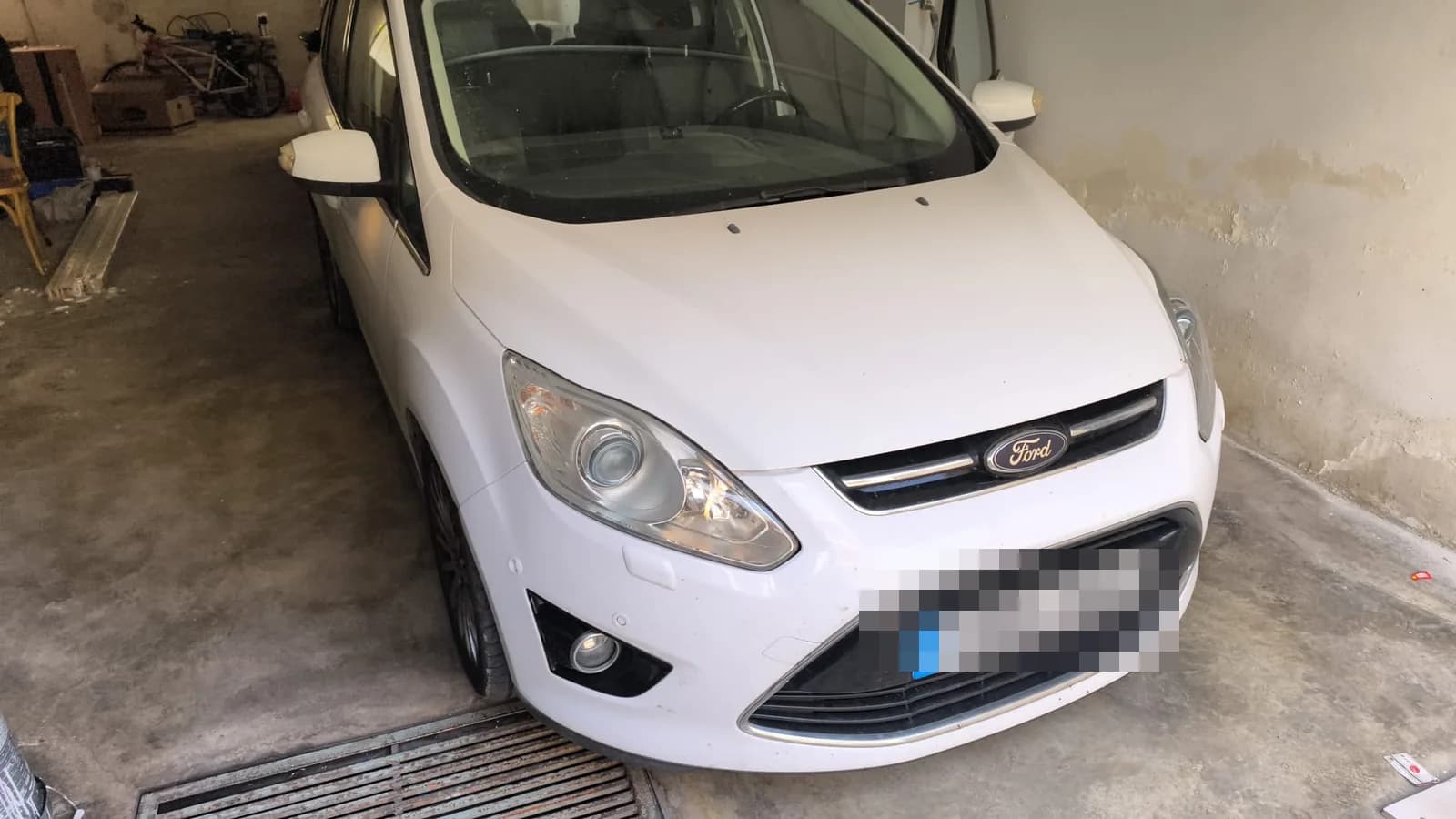 Ford C-Max blanco con el frontal detallado en el taller