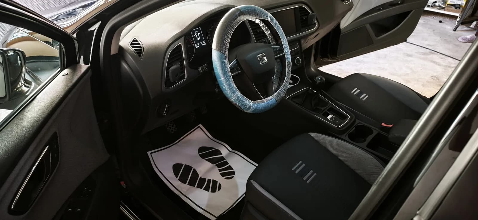 Volante del SEAT León protegido y alfombrilla de papel tras el detallado interior