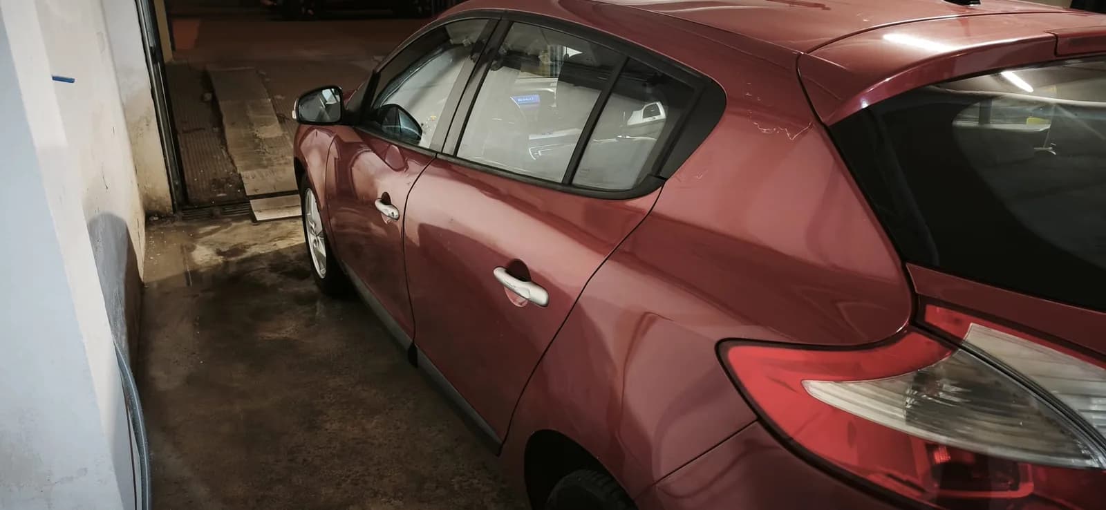 Lateral de un Renault Mégane rojo detallado en el garaje