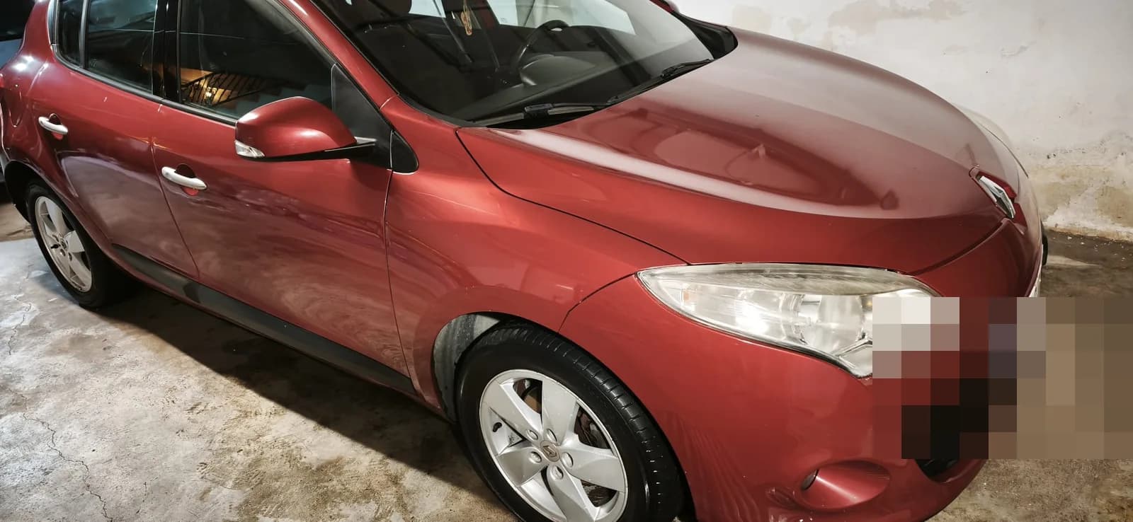 Renault Mégane rojo en tres cuartos tras el lavado de detalle