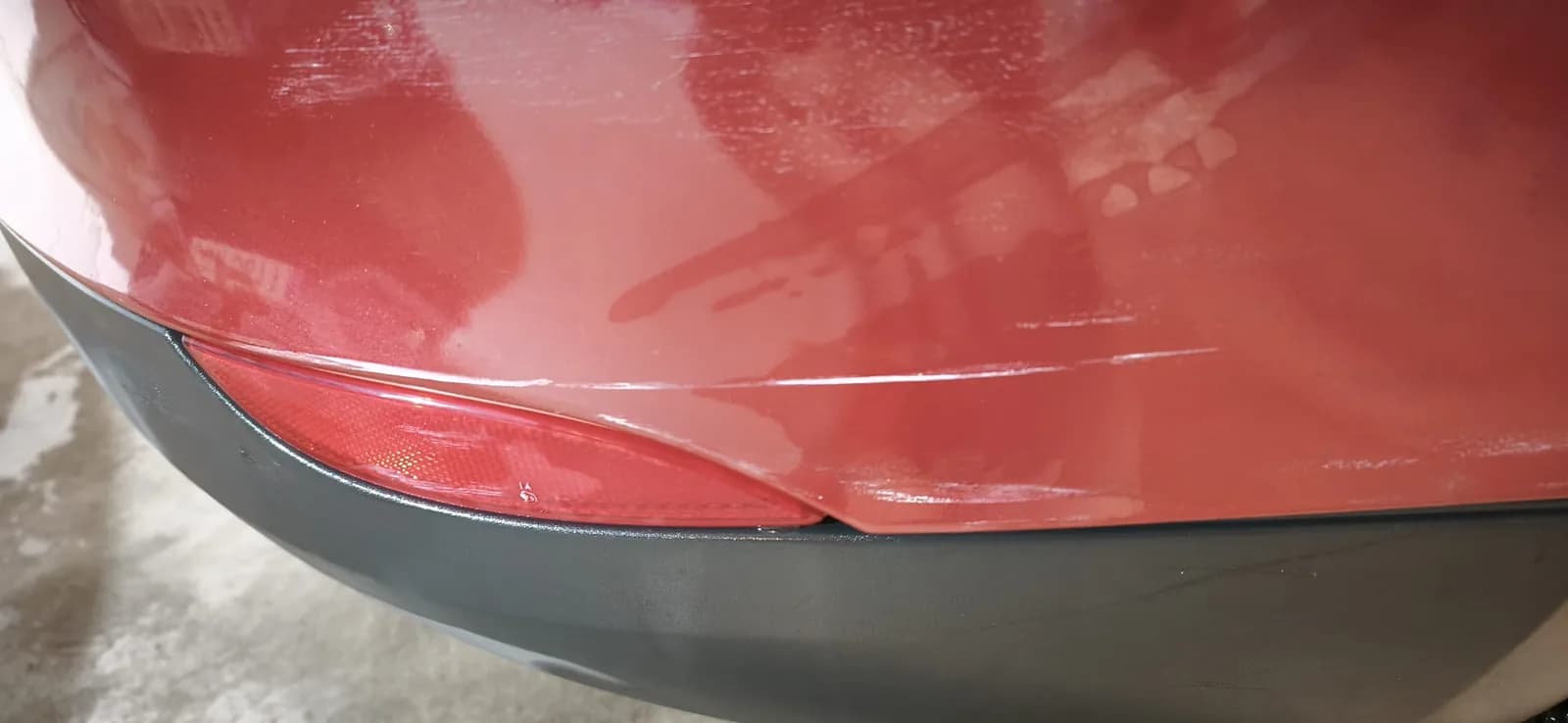 Paragolpes rojo con acabado brillante reflejando el taller