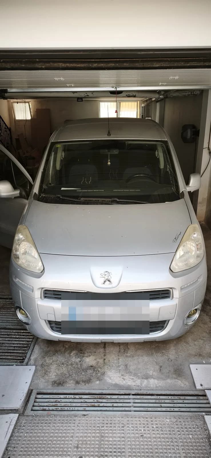Peugeot Partner plateado con el frontal detallado en el taller