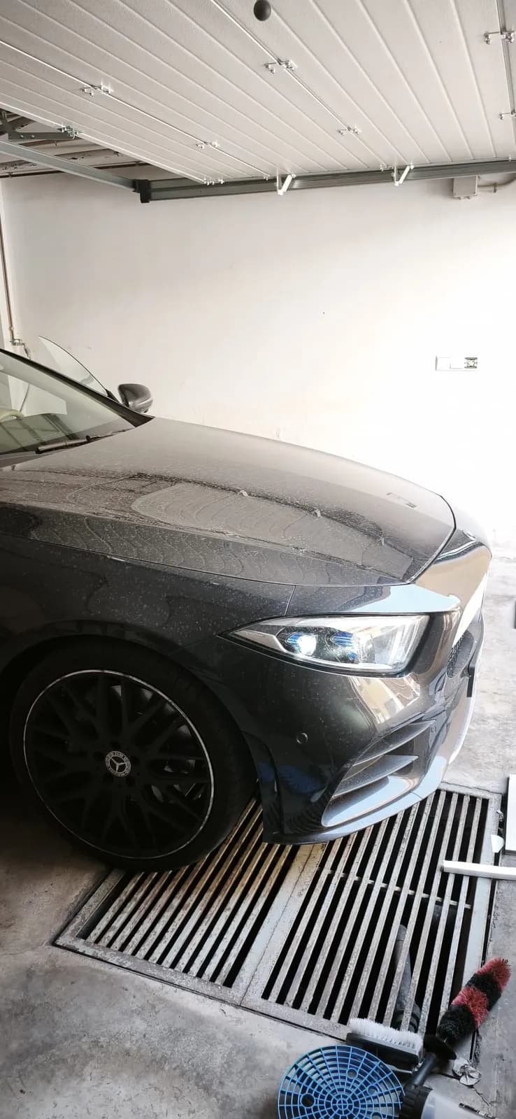 Frontal de un Mercedes mojado durante el lavado de detalle