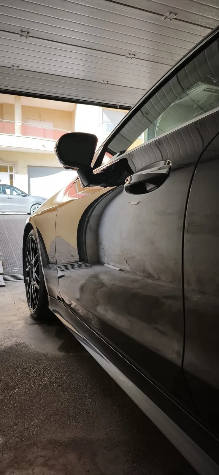 Lateral de coche negro con brillo espejo tras el lavado